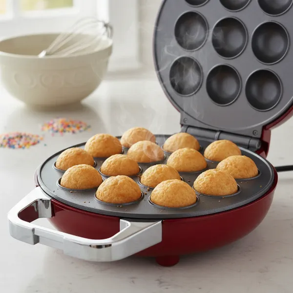 A Betty Crocker cake pop maker with open lid showing perfectly baked, round cake pops in cavities.