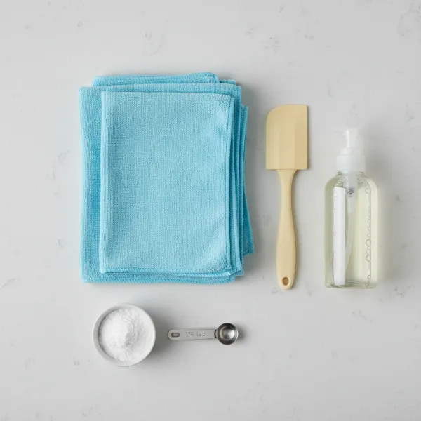 Essential tools and supplies for cleaning an electric cake maker, including soft cloths and soap.